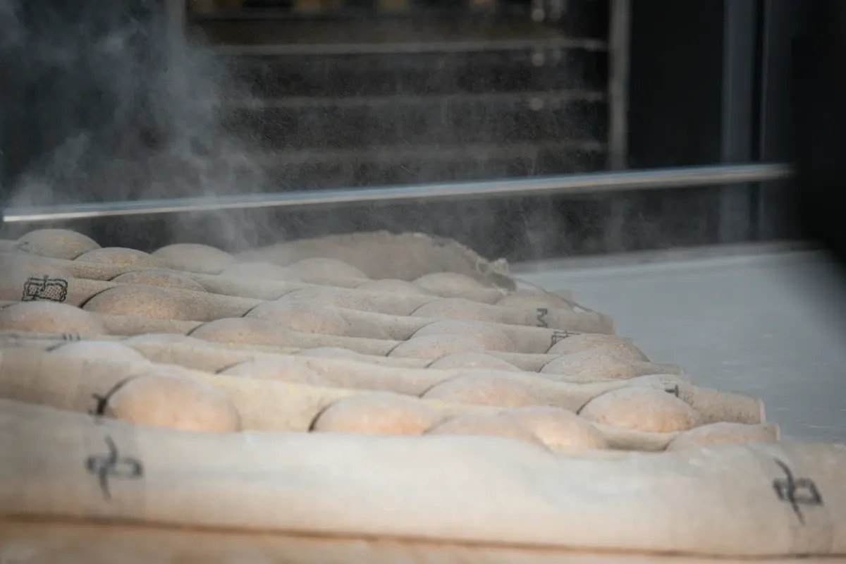Artisan bread cooling on a rack in a Berlin bakery, dusted with flour.
