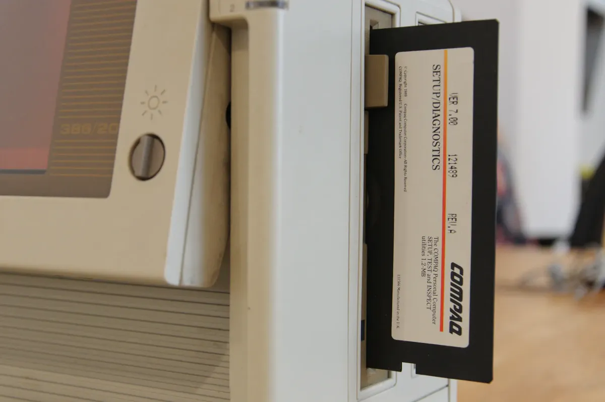 Close-up of a vintage computer showing a floppy disk in the drive.